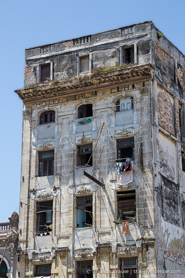 A rough looking old apartment building.