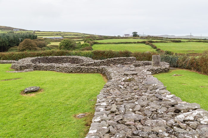 Stone walls at Reask with green fields in the background.